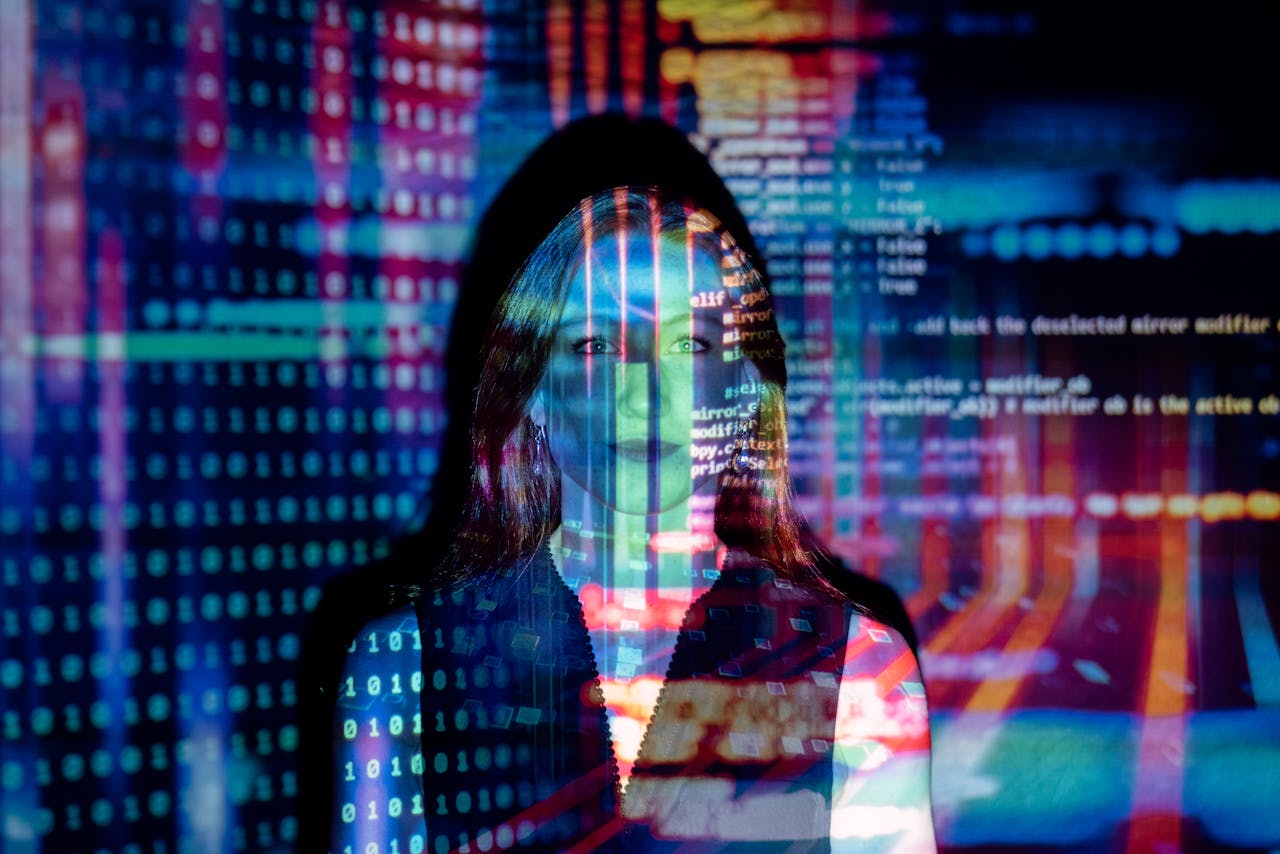 heros-img A woman with digital code projections on her face, representing technology and future concepts.